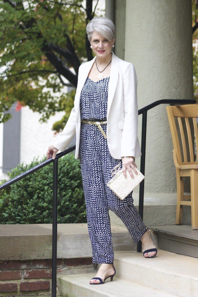 Woman over 50 in white blazer over blue patterned midi dress