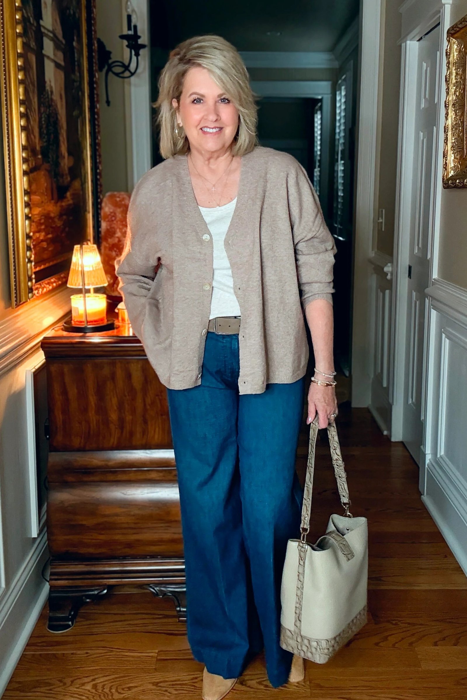 Taupe open cardigan over white top with teal blue jeans and cream tote