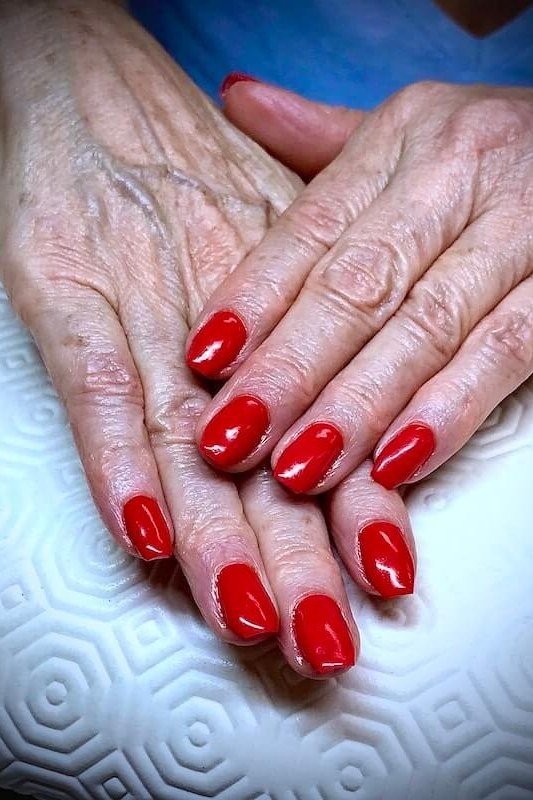 short oval, classic bright red, two very mature hands , for women over 60