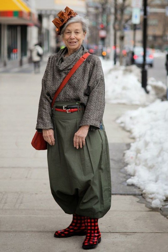 Stylish winter outfit for women over 60: gray cowl-neck knit sweater with olive balloon pants and red crossbody bag