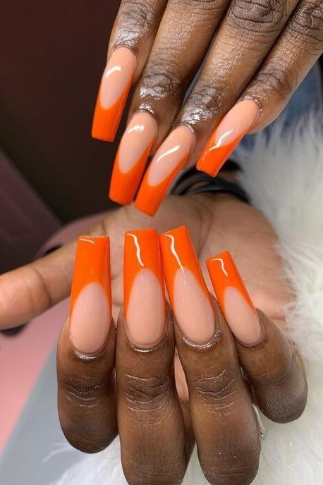 Bright orange French tip gel nails on nude base, dark skin, bold fall nail design