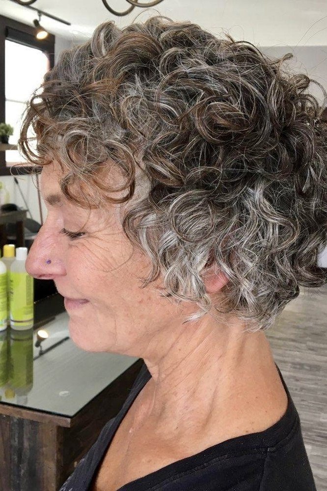 Salt and pepper curly bixie haircut side view in salon setting for women over 60