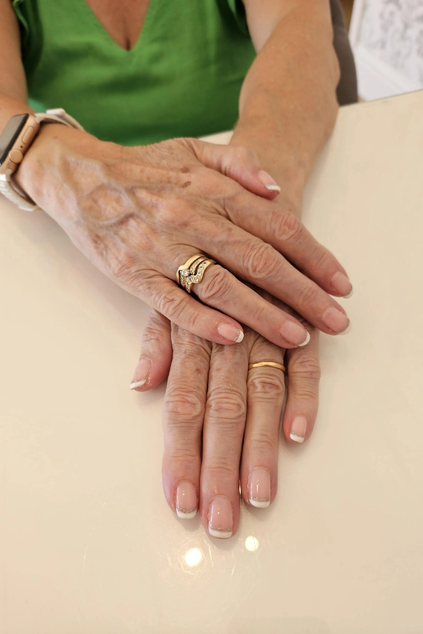 Timeless French manicure on older hands wearing a simple watch