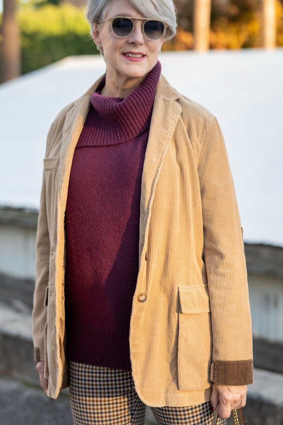 Tan suede jacket with burgundy turtleneck and houndstooth trousers