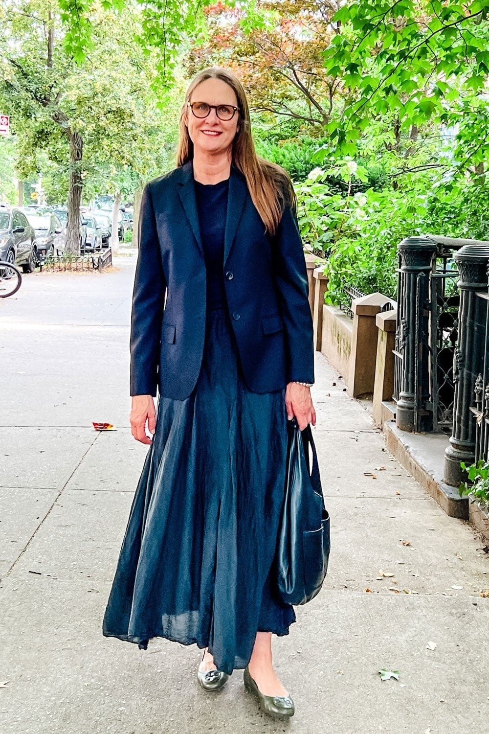 Navy blazer with navy pleated maxi skirt on a street