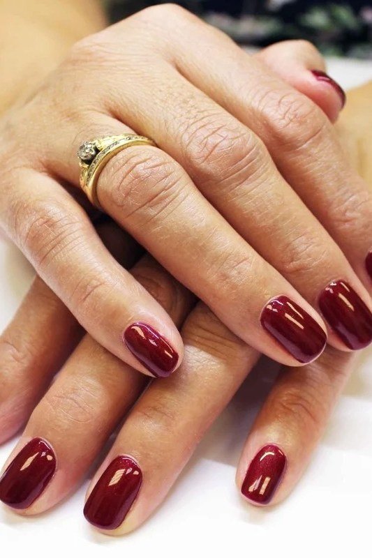 Deep Burgundy Oval Nails on Hands with Rings - old money fall nail color for women over 40