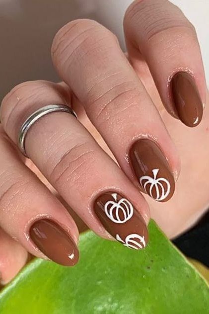 10. Chocolate Brown Nails With White Pumpkin Line Art - Thanksgiving nail art idea for women over 50