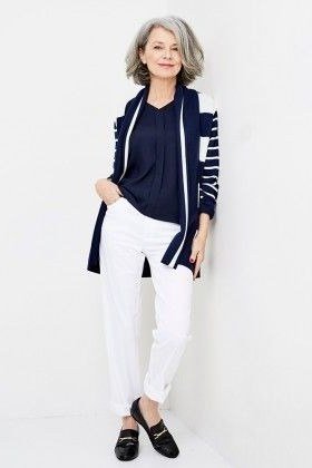 Older woman wearing a navy striped cardigan with a white top and white jeans
