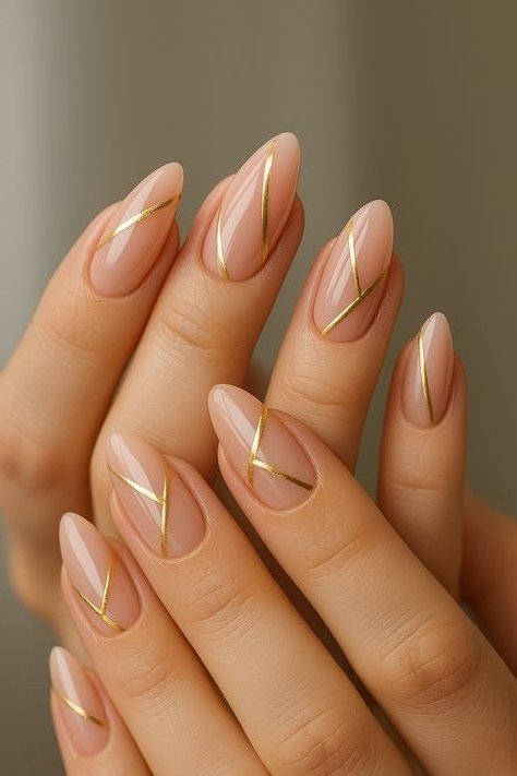 Nude almond nails with gold diagonal lines, sophisticated nail design for women over 50