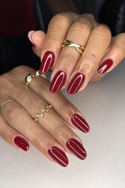 Oxblood nails on two hands with gold bracelet