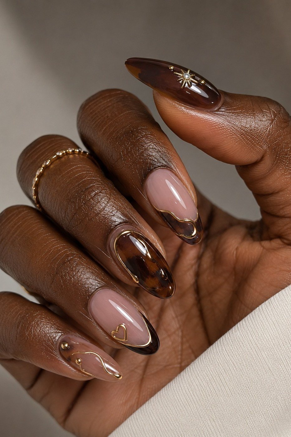 Tortoiseshell brown almond gel nails on dark skin, classic fall tortoise nail design