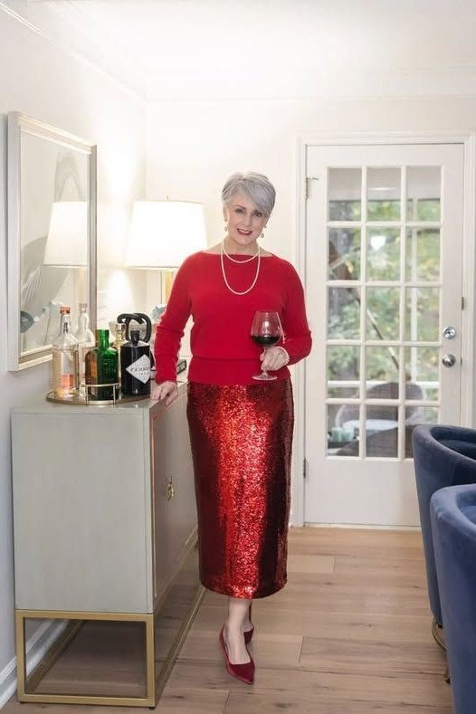 holiday evening outfit for women over 60: red knit top with red sequin skirt
