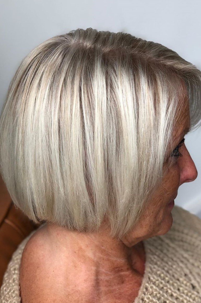 Sleek silver-white straight bob in sharp side profile for women over 60