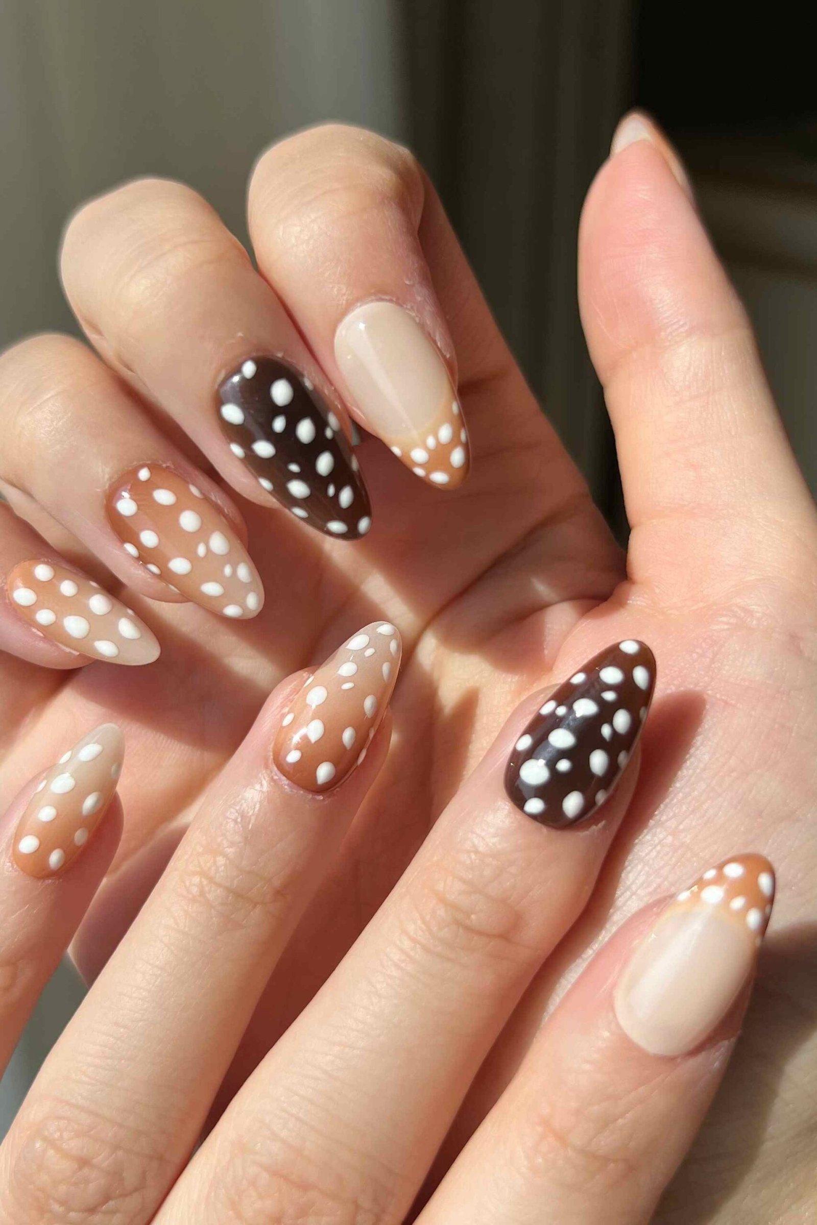 Nude almond nails with black and brown and white fawn spot mix design