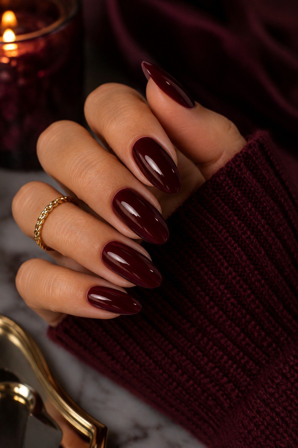 Deep oxblood nails in cozy dark setting