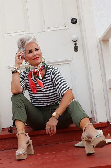 Woman over 50 wearing striped tee with red scarf and olive pants, everyday casual outfit idea