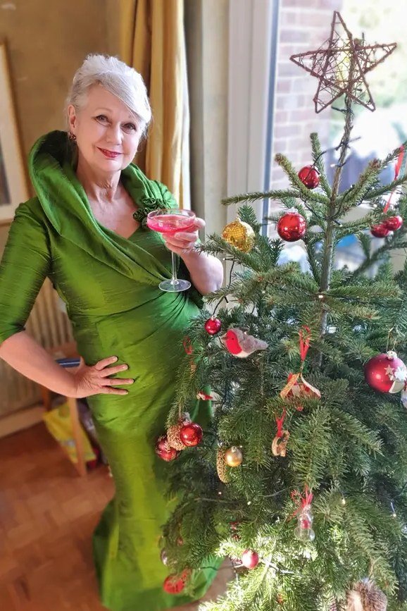 holiday evening outfit for women over 60: emerald green draped one shoulder gown