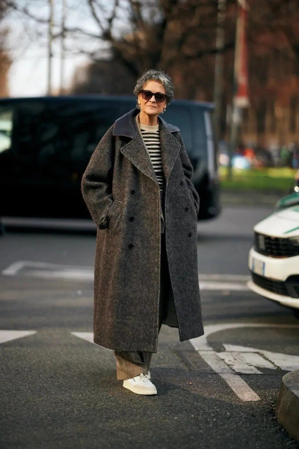 Effortlessly chic fall outfit for women over 60: oversized charcoal coat with striped top and sneakers