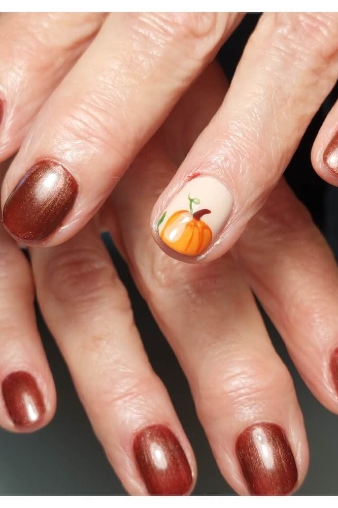 Metallic Copper Nails with a Pumpkin Accent, fall nail color idea for women over 50