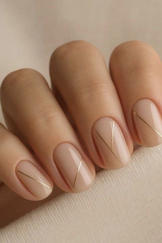 Nude short nails with gold line accents, sophisticated nail design for women over 50