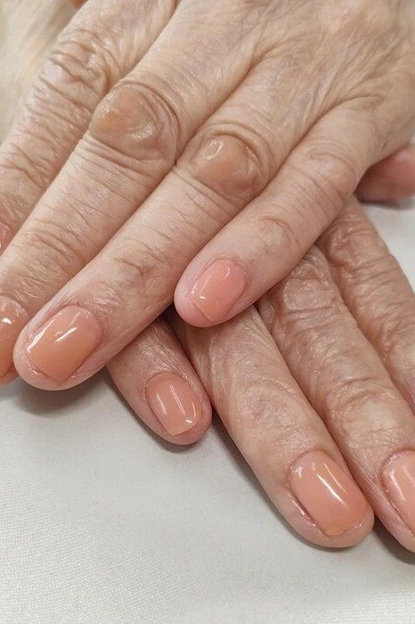 sheer peach short oval gel nails, warm peach nail color for older women