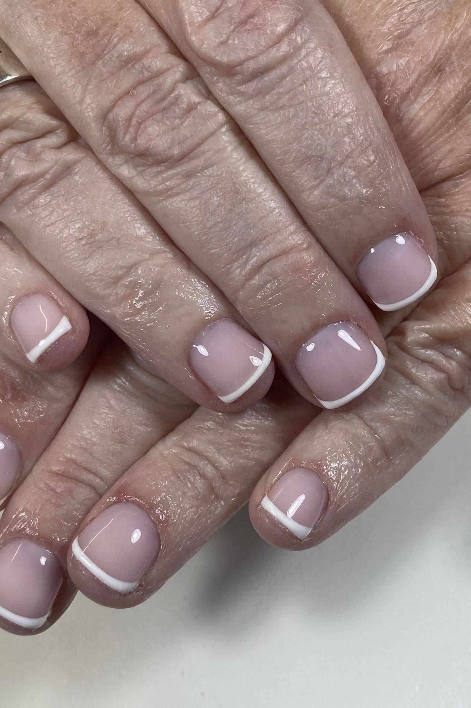 Mauve French manicure close up on an older hand