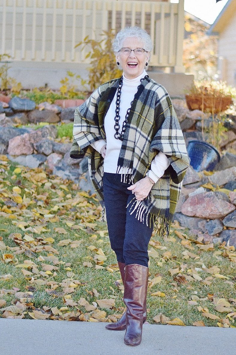 Plaid poncho with dark jeans fall outfit idea for women over 60