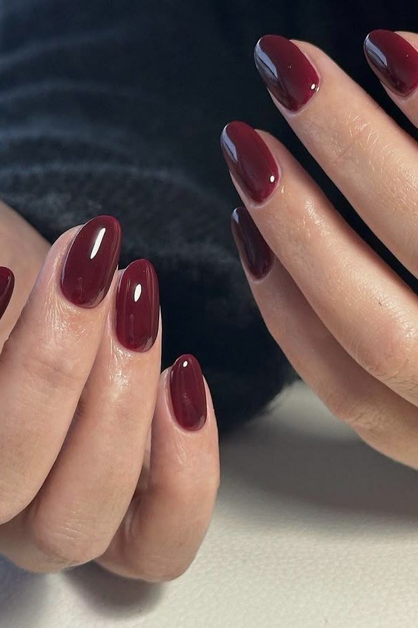short almond, deep burgundy red, two hands on dark background , for women over 60