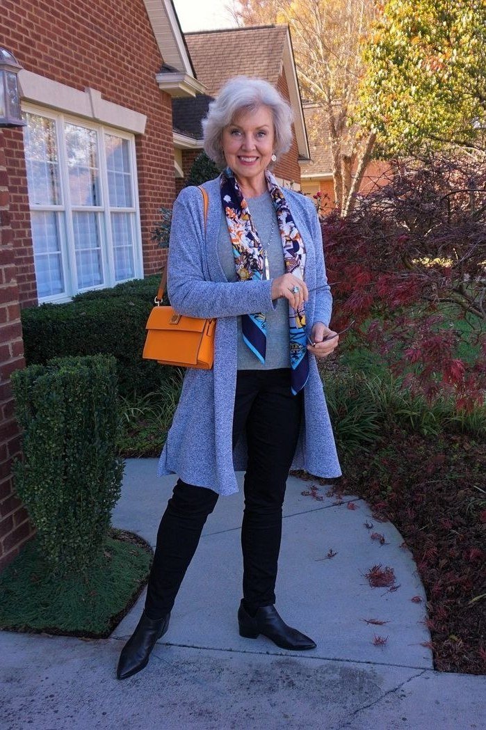 Casual fall outfit for women over 60: grey longline cardigan, black jeans, grey sneakers