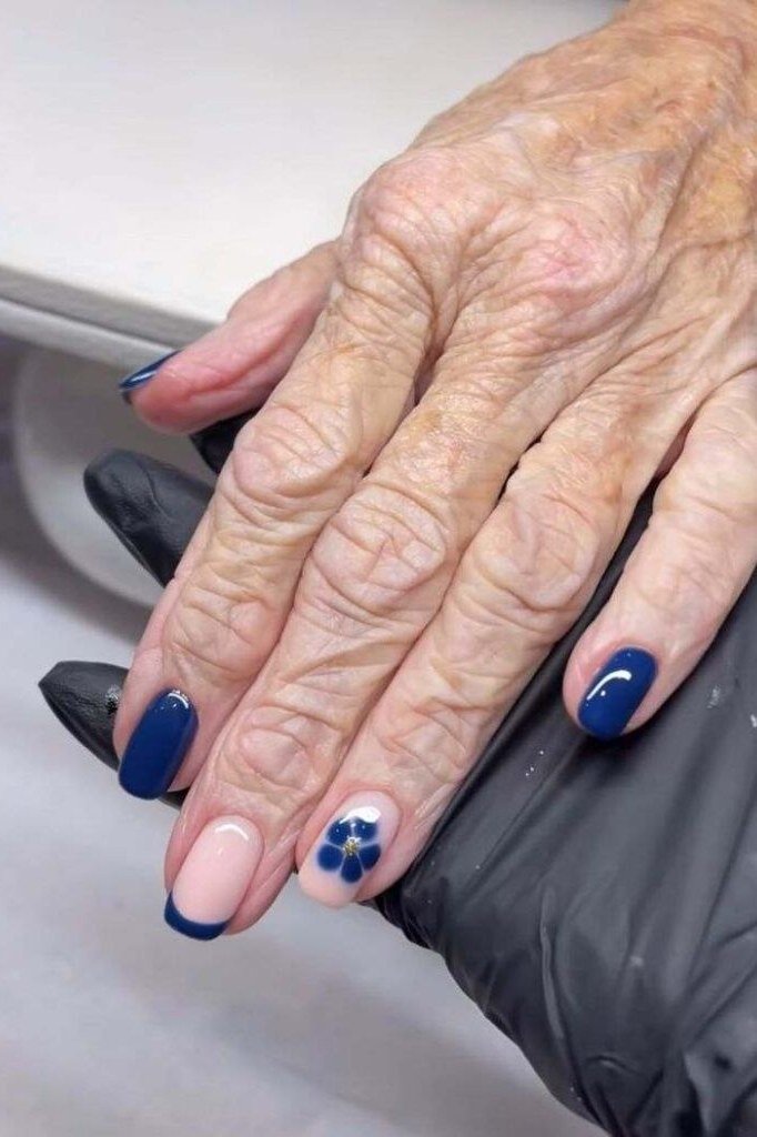 Navy French Tips With Blue Flower Accent - winter nail trend for older women over 70