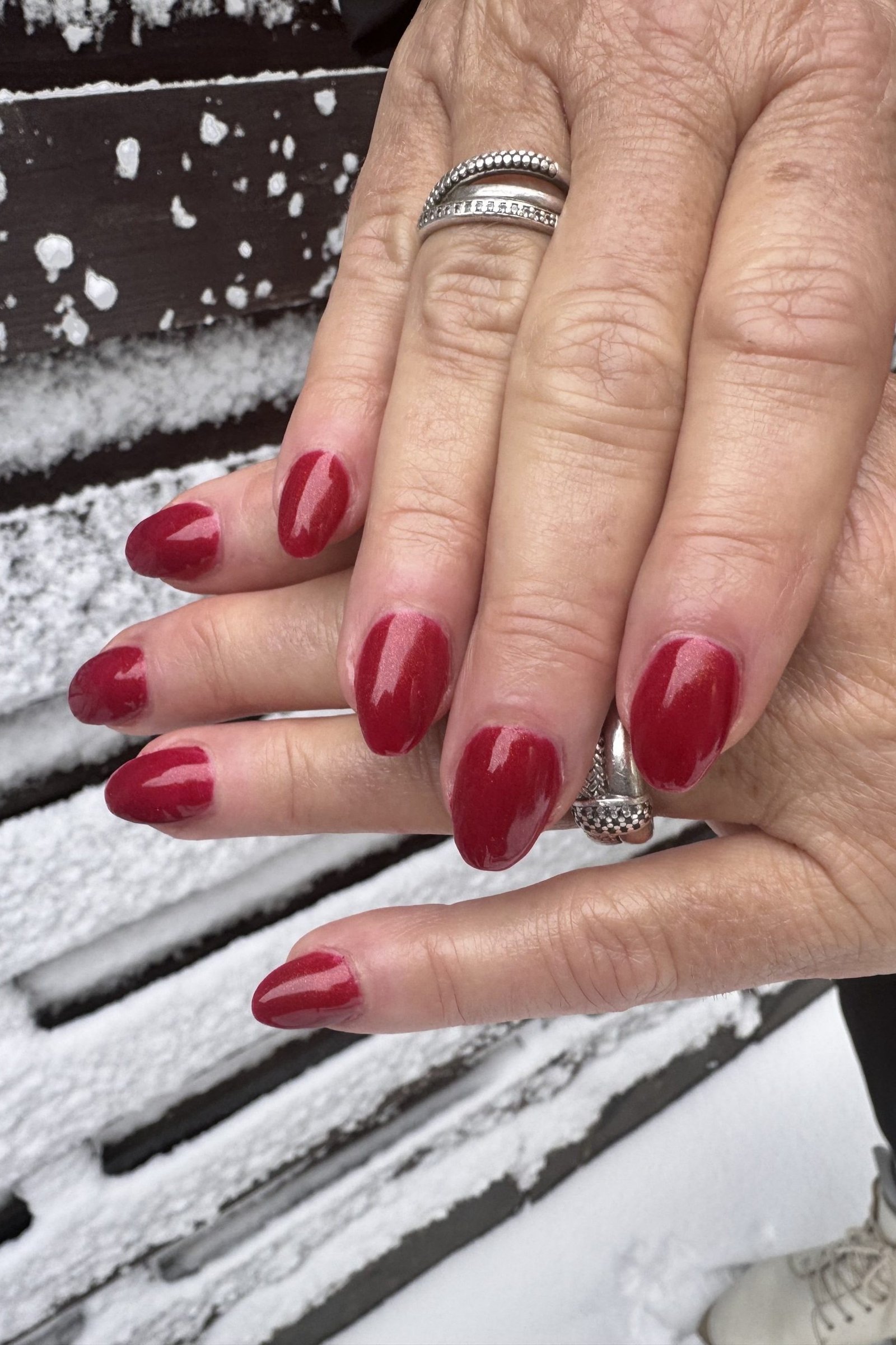 Older hands, classic red nails in the snow - classy Christmas nail idea for women over 70