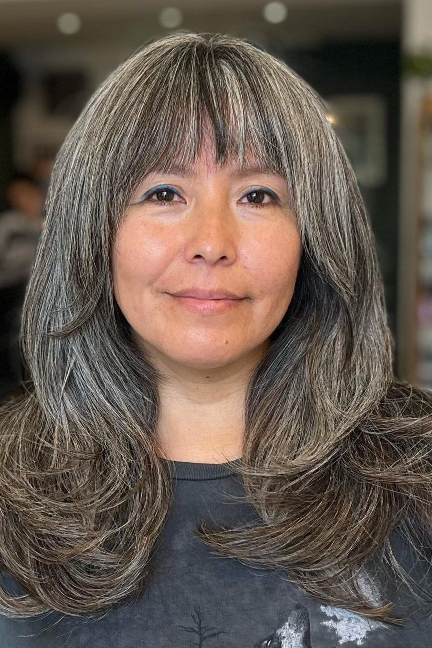 long grey soft waves with bangs, smiling front view hairstyle for women over 70