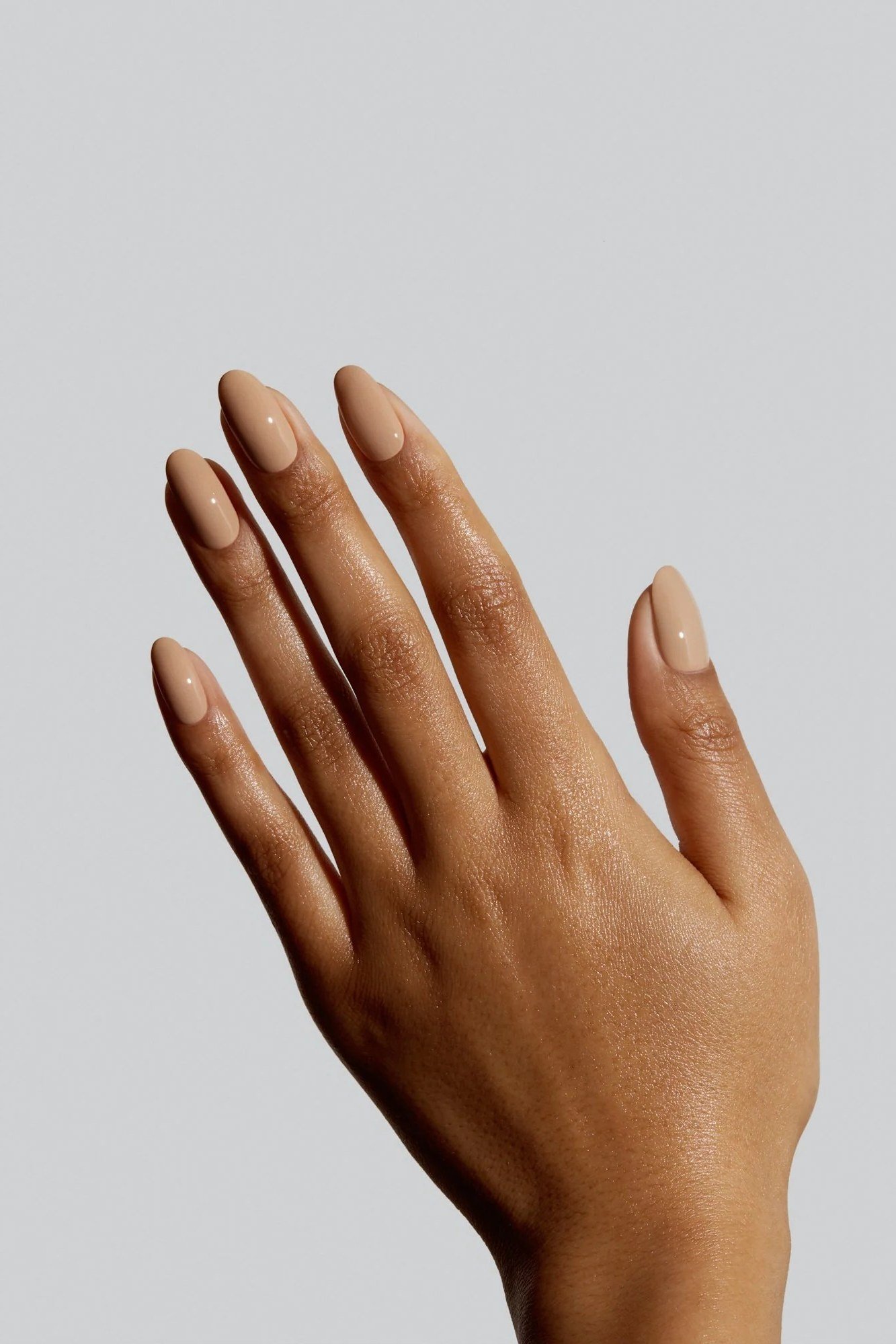 Slim nude almond nails on grey background