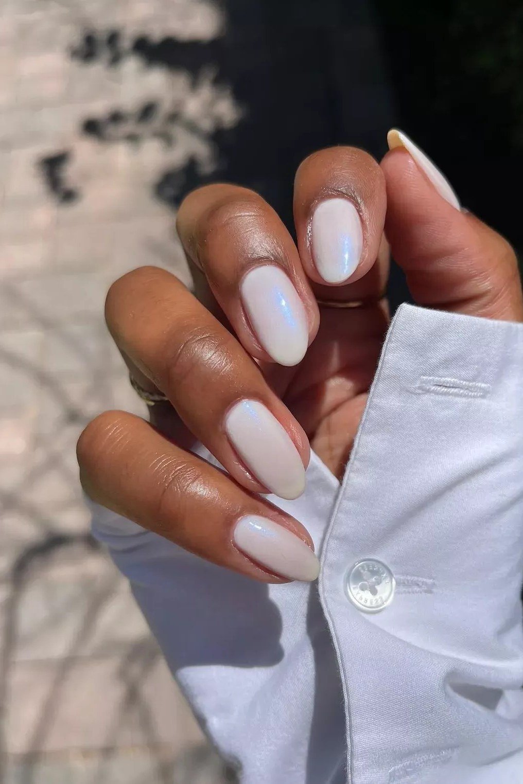 Milky white shimmer nails with a white shirt cuff
