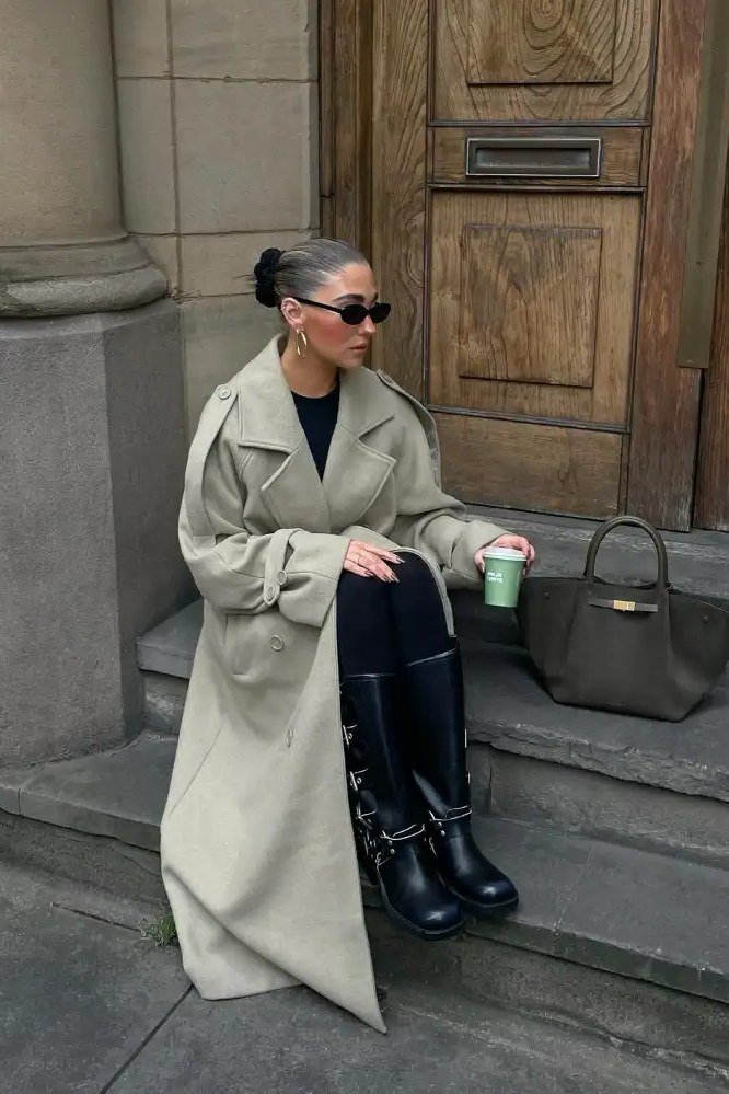 Sage trench coat with black pants and tall buckle boots, edgy fall outfit for women over 40