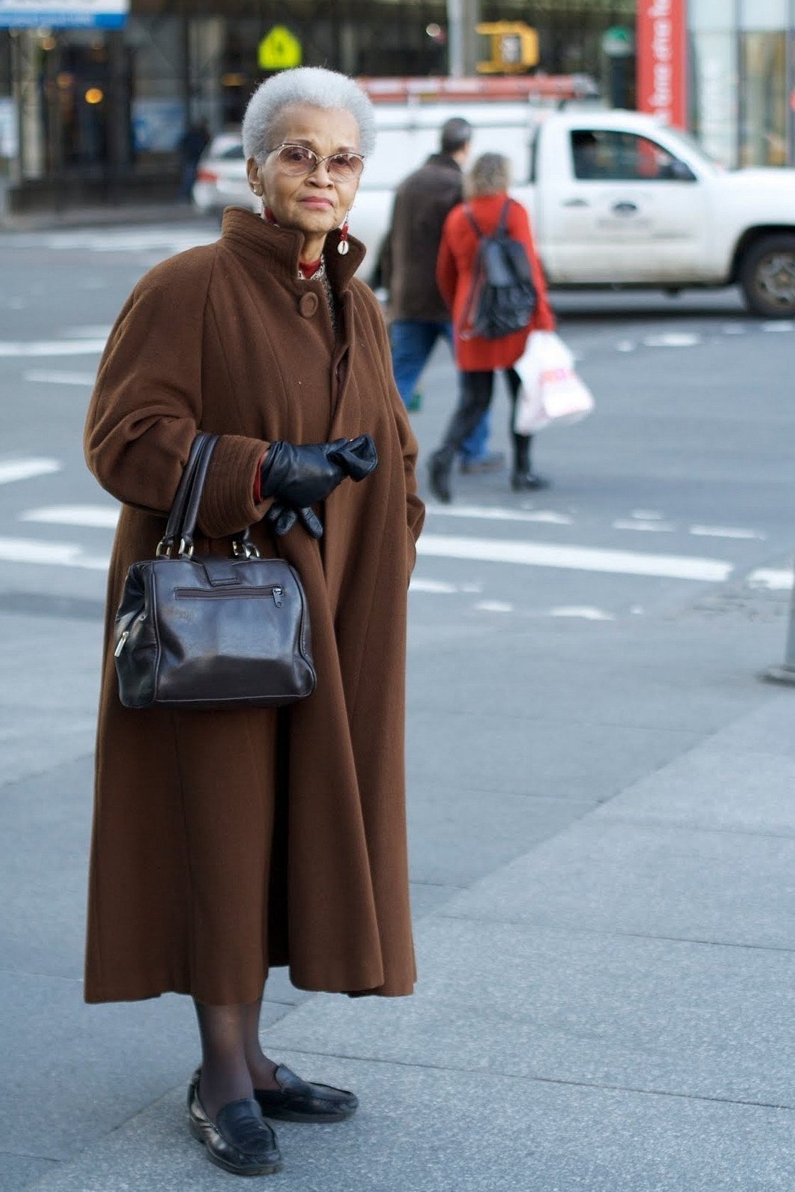 Fall city outfit for women over 50: long chocolate coat black bag