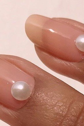 Nail art design for women over 60: single pearl accents on nude nails