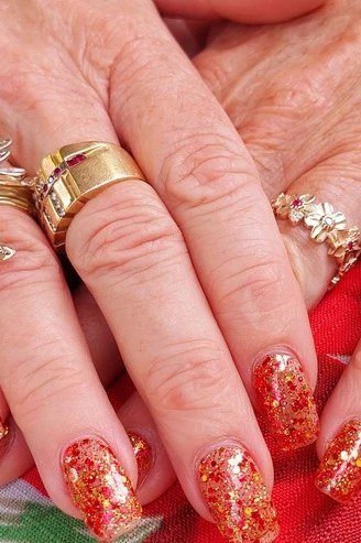Older hands, gold and red glitter festive nails - classy Christmas nail idea for women over 70