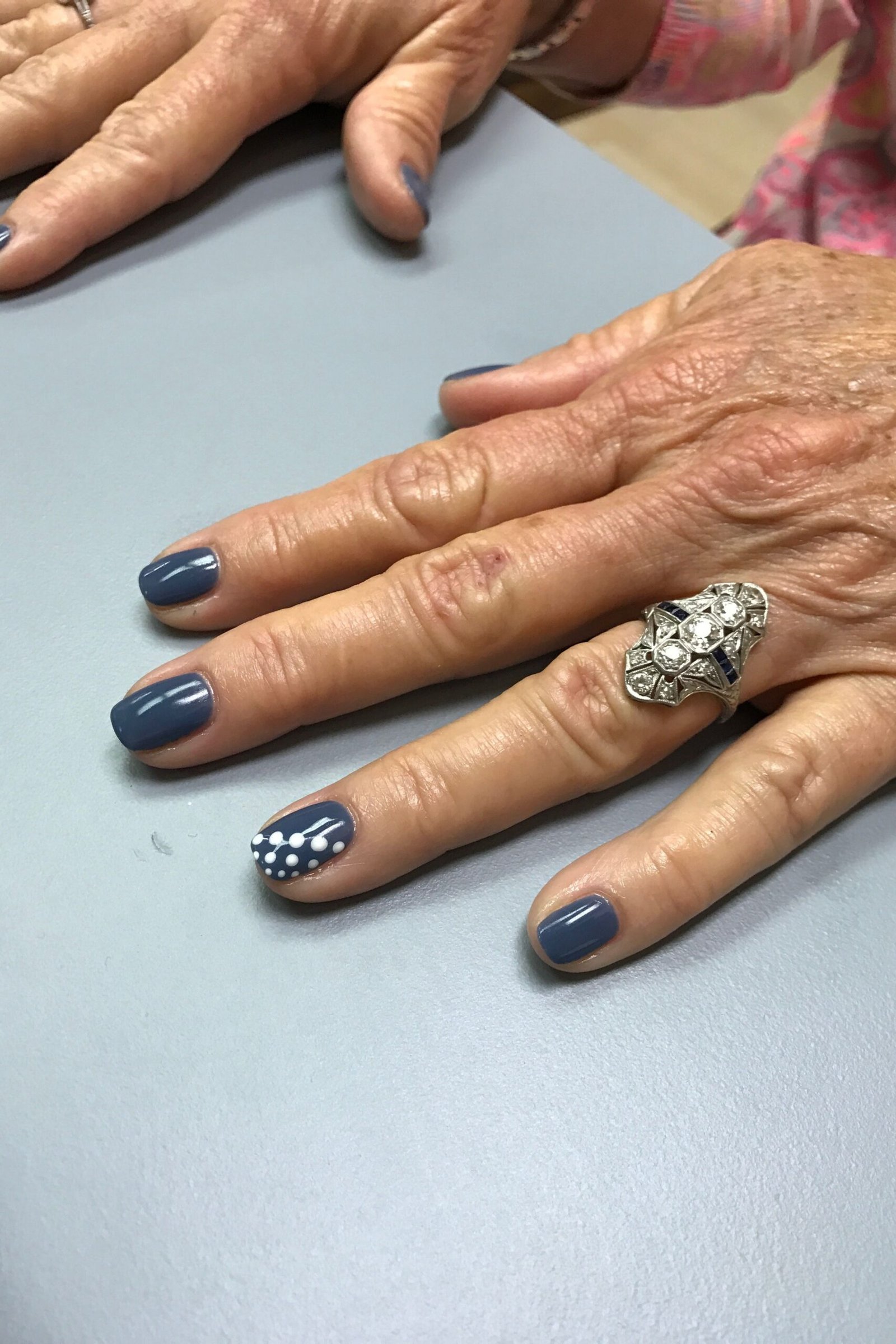 Slate blue nail polish with dotted accent nail
