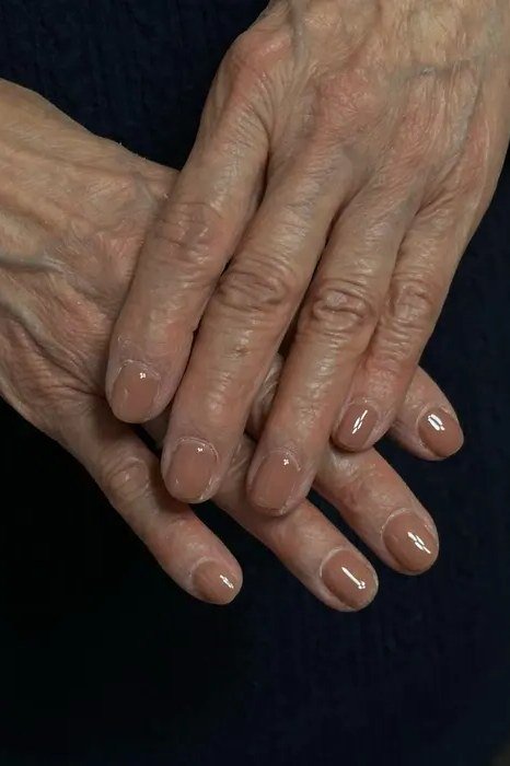 Natural nude short nails crossed on dark background