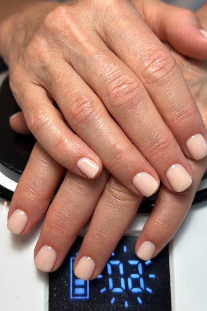 Sheer beige nude gel nails for mature hands