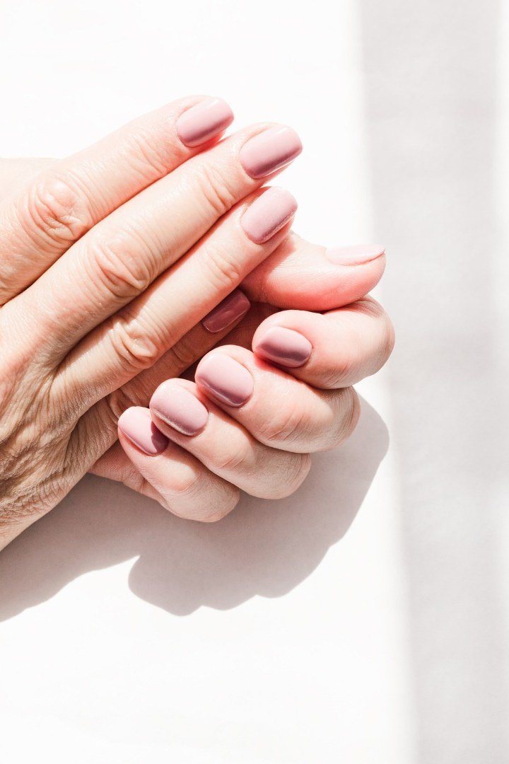 Pale pink sheer polish on mature hands - classy nail design for older women