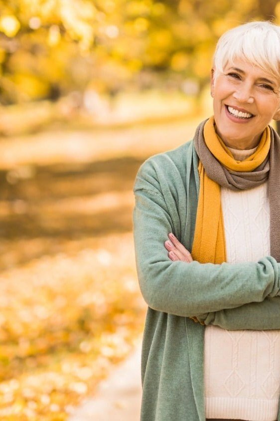 Casual fall outfit for women over 60: burgundy belted cardigan, grey jeans, black ankle boots