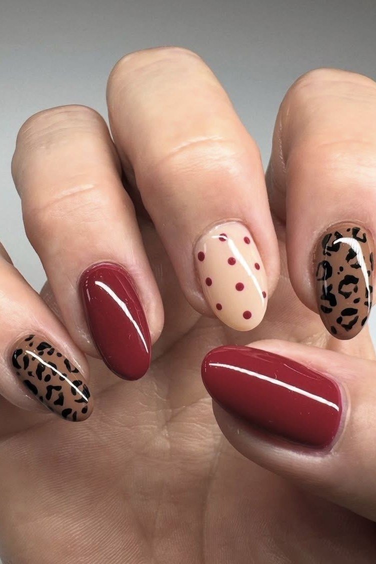 Harvest mix: cherry red, nude with brown polka dots, and leopard print accents, short oval, glossy, fall nail color for women over 40