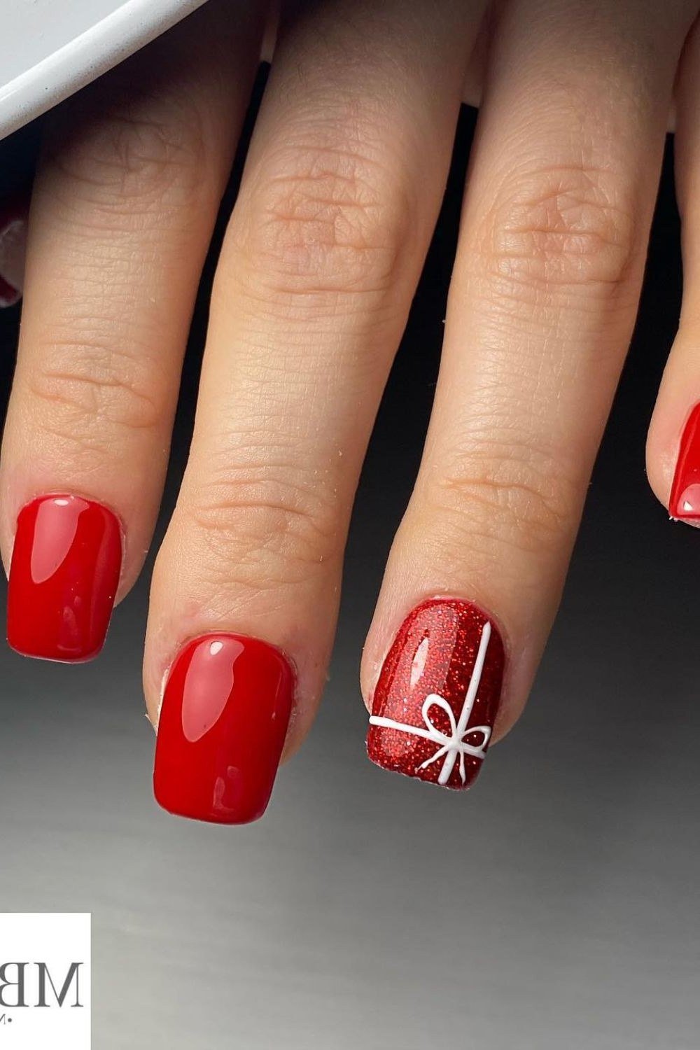 short red christmas nails with gift bow accent