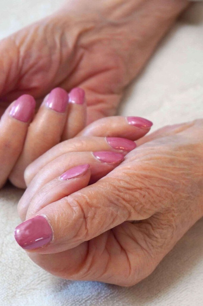 Bright pink short nails on older hands, best manicure idea for women over 60