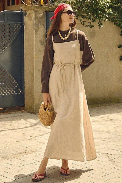 Beige apron-style midi over brown long-sleeve top, courtyard for women over 60