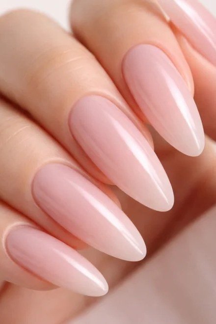 Soft milky pink polish on long almond nails