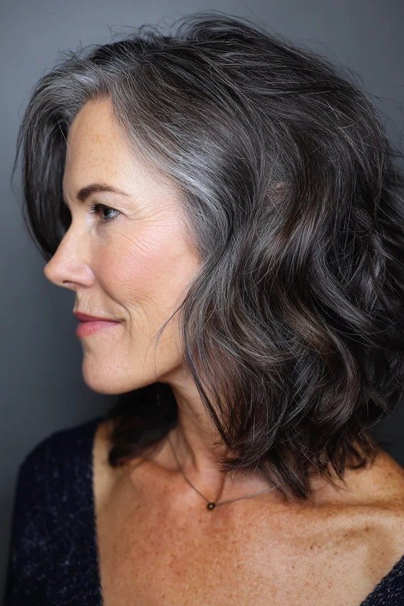 Dark charcoal wavy layered lob, side view, dark wavy lob haircut for women over 50