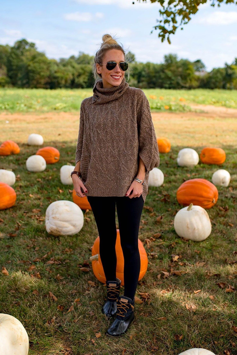 Brown knit poncho with black leggings and black lace-up boots, cozy fall weekend outfit for women over 40